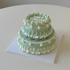 a three tiered cake sitting on top of a white table