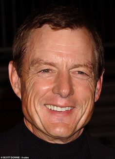 a close up of a person wearing a black shirt and smiling at the camera with his eyes closed