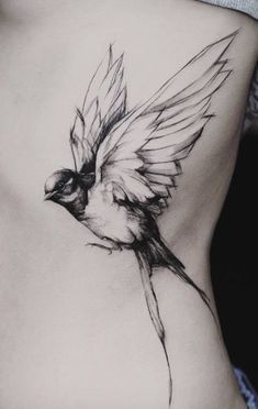 a woman's stomach with a bird tattoo on it