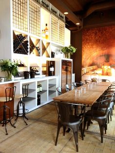 a restaurant with wooden tables and chairs in front of large windows, lit by candles