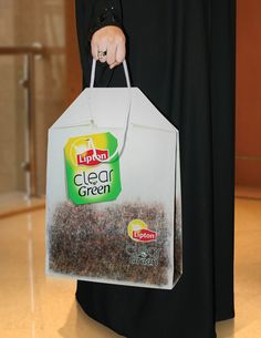 a woman holding a bag full of clear green tea bags in her hand