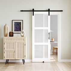 a room with a white door and some pictures on the wall next to a cabinet