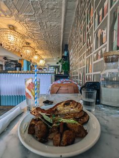 a white plate topped with food on top of a table next to a glass filled with water