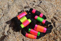 several colorful bracelets are laying on the ground