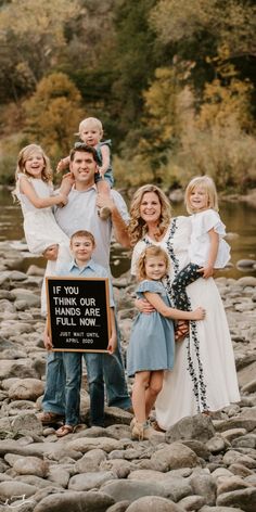 a family posing for a photo with a sign that says if you have hands are full now