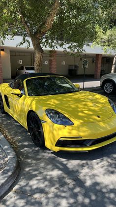 a yellow sports car parked in front of a building