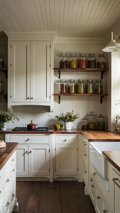 a kitchen with white cabinets and wooden floors