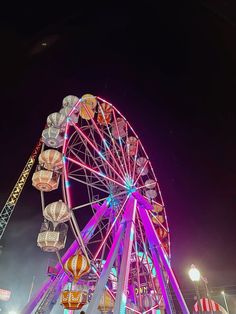 the ferris wheel is lit up at night