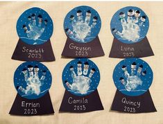 four handprinted snowmen on blue paper with names and date in the middle