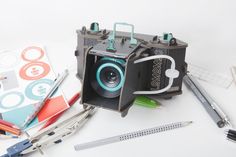 an old camera sitting on top of a table next to scissors and other office supplies