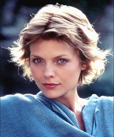 a close up of a person wearing a shawl and looking at the camera with a serious look on her face