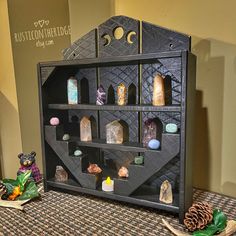 a display case with rocks and candles on it next to a pinecone tree