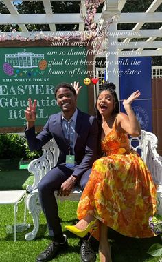 a man and woman sitting on a bench in front of a sign that says easter egg roll