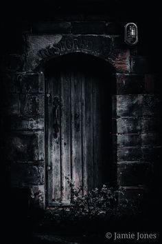 an old wooden door is lit up in the dark