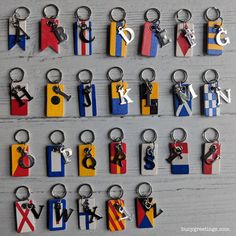 many different types of keychains are arranged on a white table with grey wood