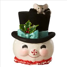 a white snowman with a black top hat and holly wreath on it's head