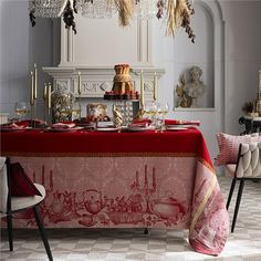 a red table cloth on top of a dining room table covered in gold and silver decorations