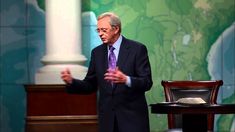 a man standing in front of a podium with his hands out