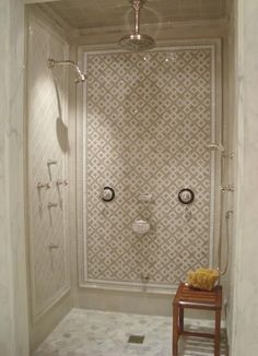 a walk in shower sitting next to a white tiled wall with two lights on it