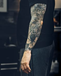 a man with a flower tattoo on his arm