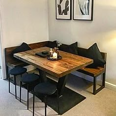 a wooden table sitting next to two black chairs