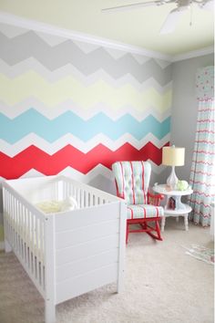 a baby's room painted with colorful chevrons