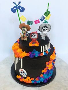 a black cake decorated with skulls and flowers