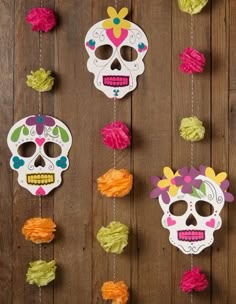 a wooden table topped with lots of colorful decorations and paper skulls hanging from the wall