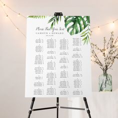 a table plan is displayed on a easel in front of a string of lights