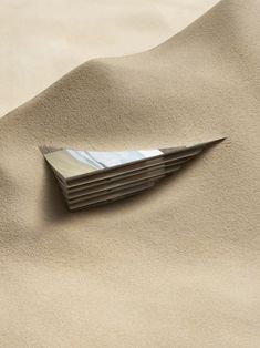 a stack of business cards sitting on top of sand