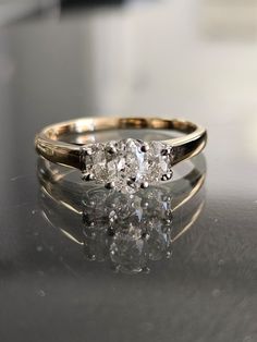 three stone diamond ring sitting on top of a table