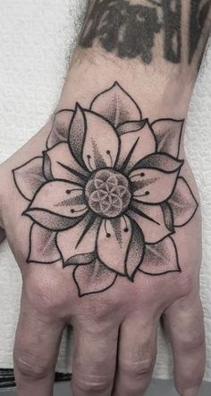 a hand with a flower tattoo on it