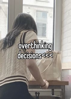 a woman sitting in front of a window with the words over thinking decision > >