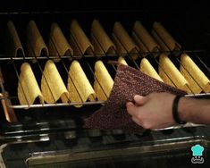 a person is cleaning an oven with a cloth and some wooden spoons in it