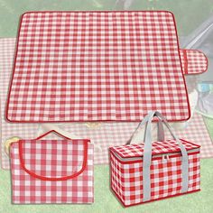 two red and white checkered picnic mats, one with a bag on the ground