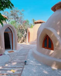 an outdoor area with several round buildings and steps leading up to the doorways that lead into another building