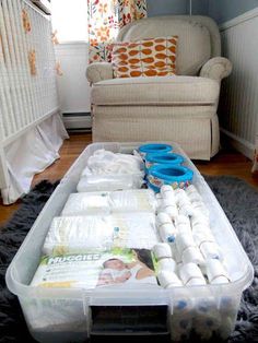 a baby crib in the middle of a living room filled with diapers and blankets