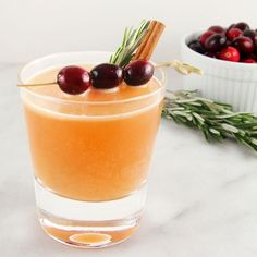 a glass filled with orange juice and garnished with cranberries