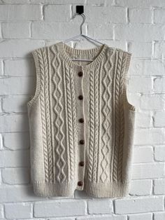 a white sweater vest hanging on a brick wall