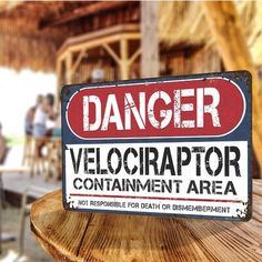 a sign that says danger velocrapor containment area on a wooden table