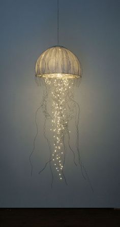 a light hanging from the ceiling in a room with lights on it's sides