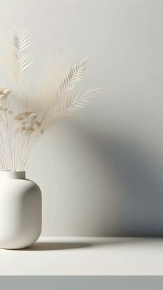 a white vase filled with flowers on top of a table next to a gray wall