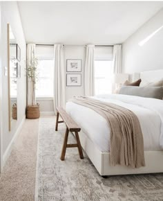 a bedroom with white walls and carpeted flooring has a large bed in it