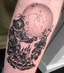 a man with a spaceman tattoo on his arm