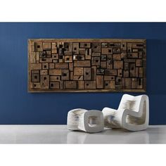 two white chairs sitting next to each other in front of a wall with wooden blocks on it