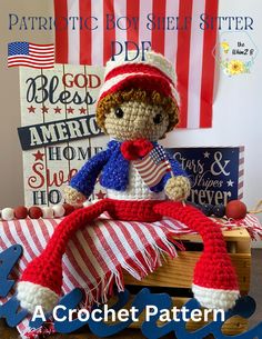 a crocheted doll sitting on top of a wooden crate with an american flag