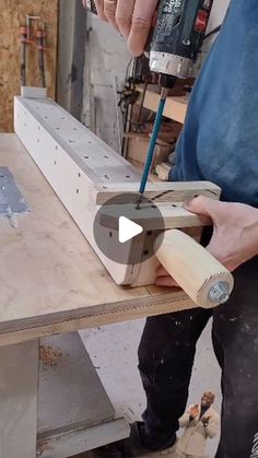 a man is using a drill to make a piece of wood