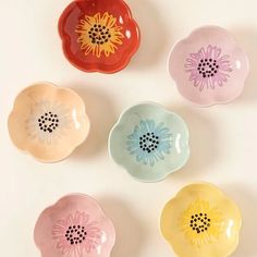 four flower shaped dishes sitting on top of a table