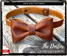 a brown leather bow tie sitting on top of a wooden table