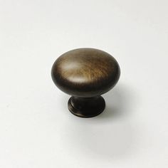 a wooden knob on a white surface